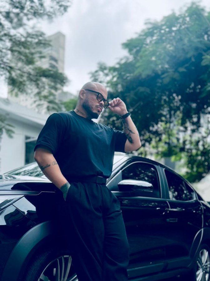 Juan Bamonde de óculos escuros, encostado num carro preto